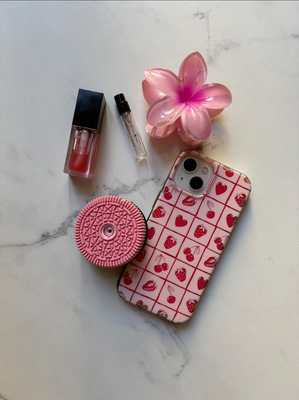 Retropia Pink Edition lens in a pink flat-lay with lip oil, perfume and a flower hair clip